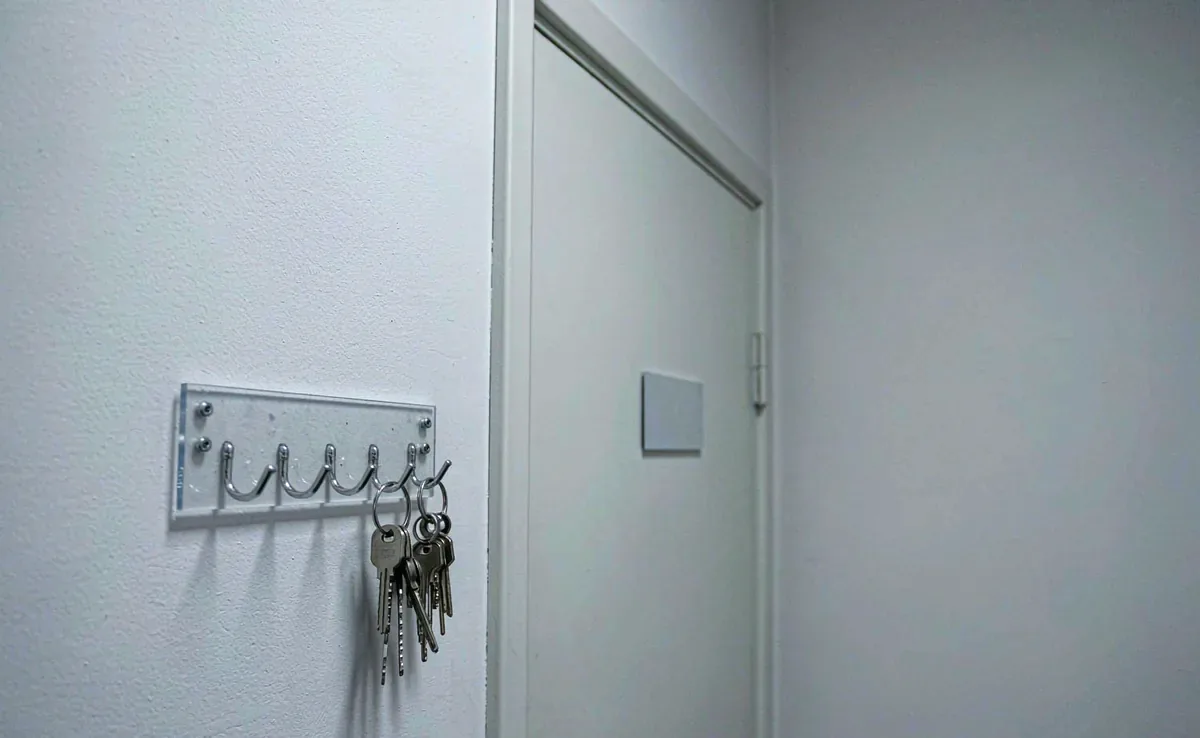 实验室门外的钥匙挂钩板，几个挂钩已经空了，旁边是关着的房门